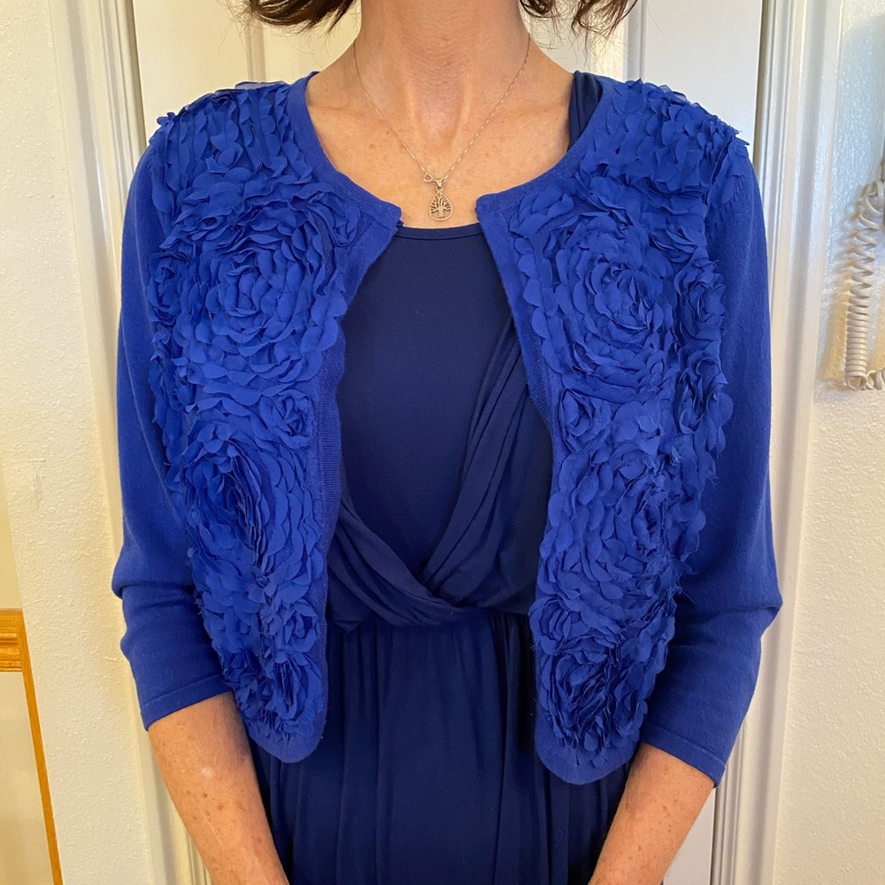 Blue sweater jacket with floral details.